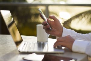 businessman in the morning with a cell phone, laptop and coffee How To Look For A Job In A Full Time Executive Job